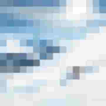 Skifahrer fährt dynamisch eine verschneite Berghangpiste bei Sonnenschein hinab