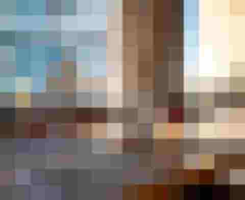 eingedeckter Restauranttisch mit Gläsern, Besteck und Blick durch große Fenster